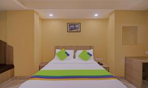 a bedroom with a bed with green and white sheets at Treebo Trend Fourth Avenue in Chennai