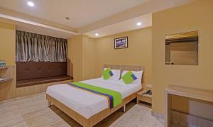 a hotel room with a bed and a tv at Treebo Fourth Avenue in Chennai