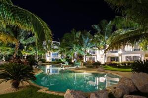 a swimming pool with palm trees in front of a building at Sunny garden in La Laguna