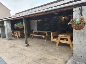 a patio with wooden benches and potted plants at Gordon's Guesthouse in Loughrea