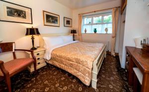 a bedroom with a bed and a desk and a window at The Gallery B&B, the Glen, Kinsale ,County Cork in Kinsale