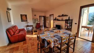 ein Wohnzimmer mit einem Tisch und einem Stuhl in der Unterkunft Stanza con terrazzo privato Le Vitterelle in Zocca