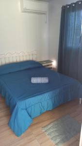 a bedroom with a blue bed with a blue comforter at La casita Bella Unión 