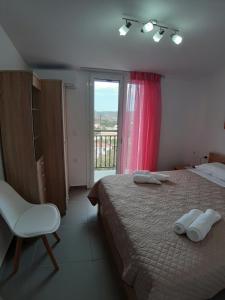 a bedroom with a bed and a chair and a window at FANERO Guesthouse in Keri