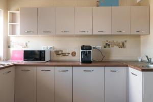 a kitchen with white cabinets and a coffee maker at Pensiunea Dolosman in Jurilovca