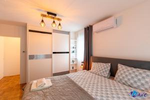a bedroom with a bed and a door with a mirror at TWO BEDROOM MODERN APARTMENT near the AIRPORT in Velika Gorica