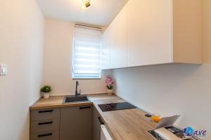 a small kitchen with white cabinets and a sink at TWO BEDROOM MODERN APARTMENT near the AIRPORT in Velika Gorica