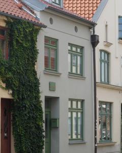 a white house with green ivy on it at Altstadthaus TimpeTe in Wismar