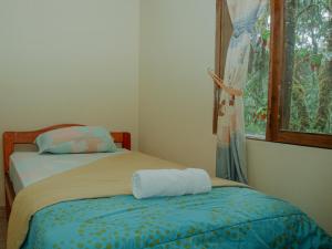 1 dormitorio con 2 camas y ventana en Birdwatchers House y Lodge, en Mindo