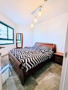 um quarto com uma cama com estampa de zebra e uma secretária em Tiberias em Tiberias