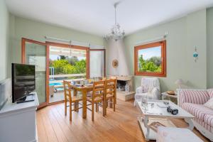 uma sala de estar com uma mesa e um sofá em SUN VILLA GLYFADA em Glyfada Fokidas