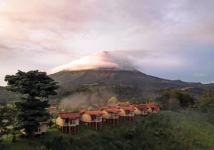 a mountain with a group of houses in front of it at Montaña de Fuego All Inclusive in Fortuna