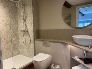 a bathroom with a shower and a toilet and a sink at Coffee & Stays at Cartmel Square in Cartmel