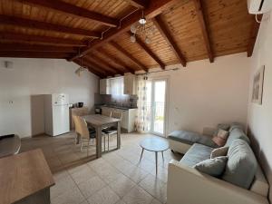 a living room with a couch and a table at Votsalo Pool Apts in Kalami