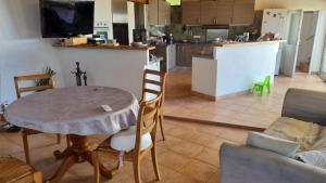 ein Wohnzimmer mit einem Tisch und einer Küche in der Unterkunft Casa Di Vadella in Santʼ Andrea-di-Cotone