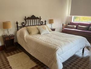 een slaapkamer met een groot bed en een bank bij Casa de campo San Agustín in Tandil