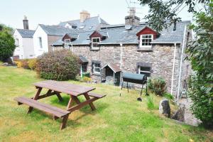 a wooden picnic table in front of a building at Cosy cottage for 2, sea views, large grounds. WiFi in Newport Pembrokeshire