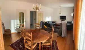 een woonkamer met een houten tafel en een bank bij De Lelie in Achel