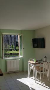 ein Esszimmer mit einem Tisch und einem Fenster in der Unterkunft Le Malpas Kingfisher in Belvès