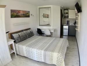 um pequeno quarto com uma cama e uma cozinha em Vila Junda em Neringa