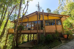 uma casa na árvore no bosque com uma grande janela em Natureza e área gourmet em Campos do Jordão em Campos do Jordão