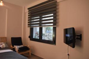 a bedroom with a window with a television and a bed at Studio2 in Katerini in Katerini