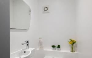 Un baño blanco con lavabo y algunas plantas. en Spacious and Modern 4 Bed Apartment next to Borough Station, en Londres 31 fotos más