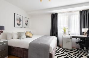 a bedroom with a bed and a desk and a window at Spacious and Modern 4 Bed Apartment next to Borough Station in London