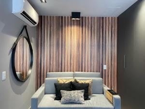 uma sala de estar com um sofá azul e um espelho em APARTAMENTO Duplex Manhattan com 3 Suites, Casal, Solteiro e Office em Goiânia