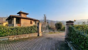 ein altes Haus mit einem Zaun und einem Tor in der Unterkunft Stanza con terrazzo privato Le Vitterelle 