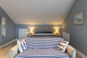 um quarto com uma cama grande e um sofá em Spindrift em Abersoch