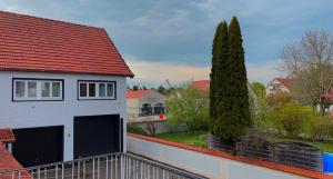 a white house with a red roof and two trees at Hotel Casa Andalucia in Hallbergmoos