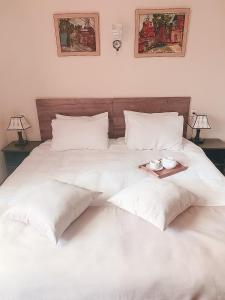 Una cama blanca con almohadas y una bandeja. en Keriya Hotel Shekvetili Kaprovani, en Shekhvetili