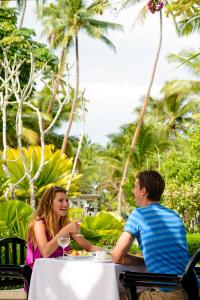 a man and a woman sitting at a table at The Warwick Fiji in Korolevu
