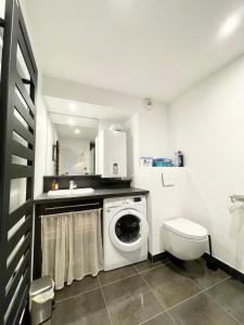 a bathroom with a washing machine and a toilet at T2 de standing Port et plages à pieds in Guidel