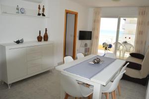 un comedor blanco con una mesa y sillas blancas en Apartamento céntrico en la playa con piscina., en Peñíscola