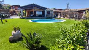 Villa Janas con piscina privata Budoni في تانايونيلا: منزل مع ساحه مع مسبح