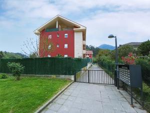 un edificio rojo con una puerta delante de un patio en APARTAMENTO LAS FRAGUAS, en Ampuero