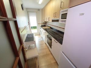 a kitchen with white cabinets and a stove top oven at APARTAMENTO LAS FRAGUAS in Ampuero