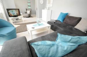 un soggiorno con divano grigio e cuscini blu di Haus Sonneneck a Haffkrug