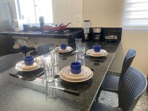 a dining table with blue cups and dishes on it at Locking´s Santo Agostinho 7 - Apto 2 quartos novo ao lado Diamond Mall in Belo Horizonte
