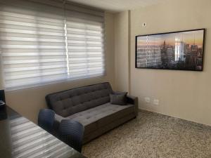 a living room with a couch and a picture on the wall at Locking´s Santo Agostinho 7 - Apto 2 quartos novo ao lado Diamond Mall in Belo Horizonte