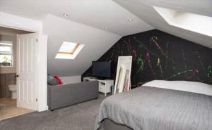a bedroom with a bed and a tv in it at Beautiful 5 bedroom house in great location. in Spon End