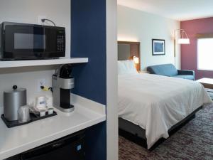 ein Hotelzimmer mit einem Bett, einer Mikrowelle und einem Zimmer in der Unterkunft Holiday Inn Express & Suites - Little Rock Downtown, an IHG Hotel in Little Rock