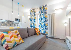 sala de estar con sofá gris y cortinas coloridas en Penthouse Alps Apartment, en Turín