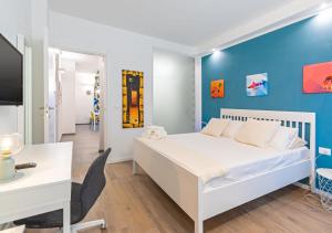 1 dormitorio con cama blanca y pared azul en Penthouse Alps Apartment, en Turín