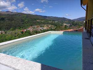 a large swimming pool on top of a house at Casa Amarela da Caniçada in Vieira do Minho