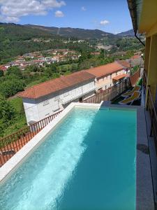 - une vue sur la piscine depuis un bâtiment dans l'établissement Casa Amarela da Caniçada, à Vieira do Minho