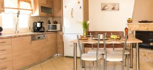 kuchnia ze stołem, krzesłami i lodówką w obiekcie Marina Mare w mieście Balíon