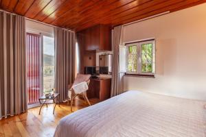 a bedroom with a bed and a desk and a kitchen at Casa do Rancho - Turismo Rural in Paranhos